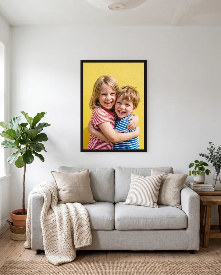 Photo mosaic of a brother and sister hugging, framed above a sofa in a bright living room